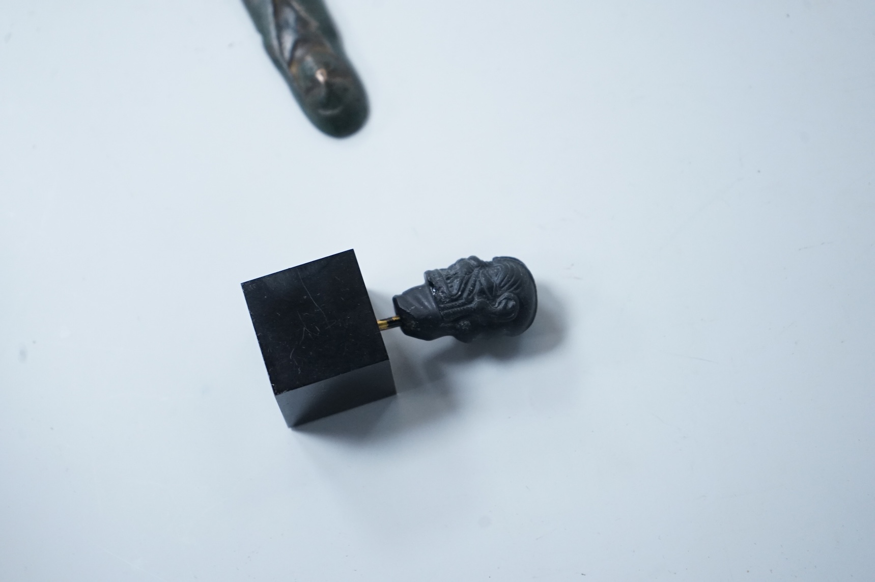 Two small antiquities with certificates - an Assyrian obsidian head of Pazuzu and a Celtic bronze offer idol